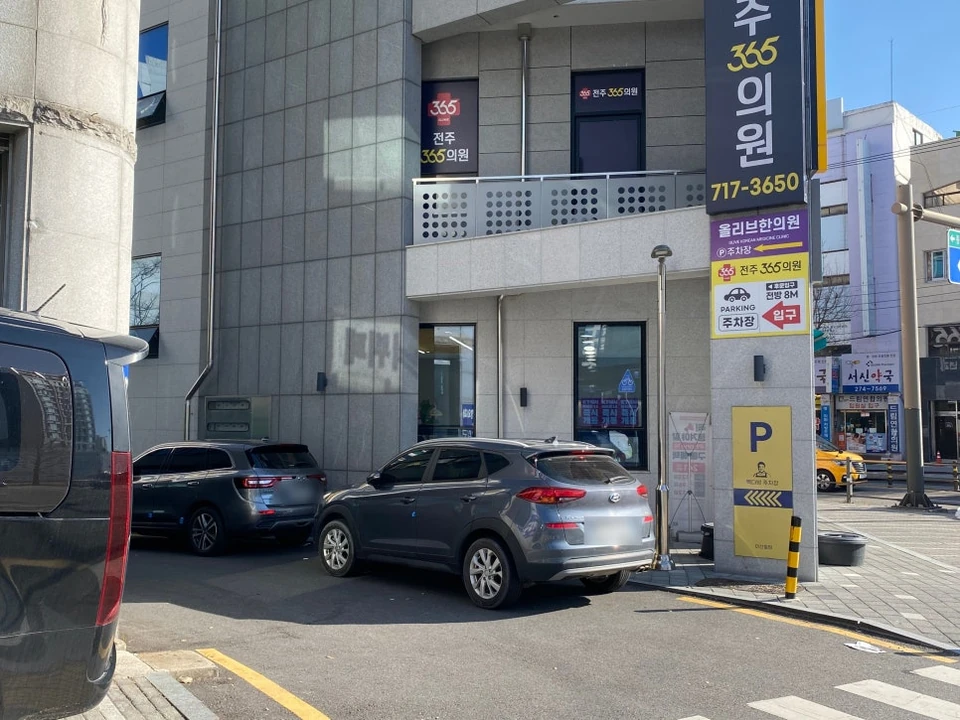 건물 옆 골목의 주차장 입구 안내